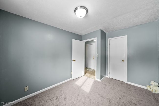 Bedroom with light colored carpet, a closet, and a textured ceiling | Image 15