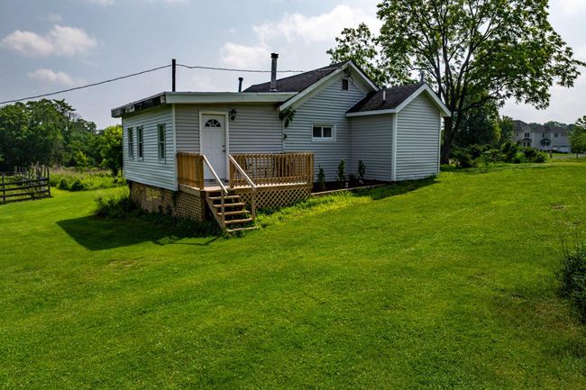 Back of house with a wooden deck, a yard, and a shingled roof | Image 39