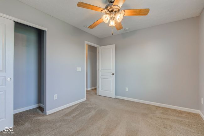 unfurnished bedroom featuring carpet flooring, ceiling fan, and a closet | Image 40