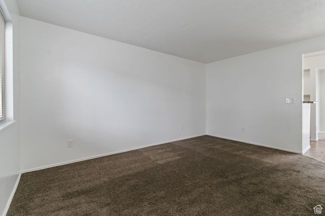 Spare room featuring dark carpet and baseboards | Image 9