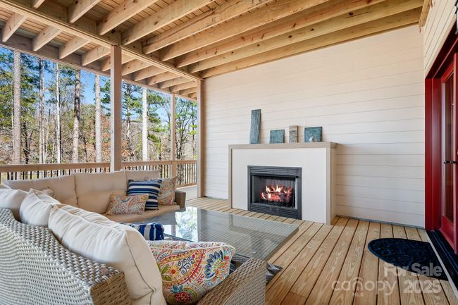 Lower level covered deck space open to the lake with sweeping views. Enjoy the gas fireplace while entertaining your guests. | Image 32