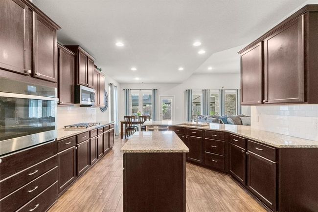 Kitchen boasts beautiful CUSTOM cabinetry, stainless steel appliances and granite countertops. | Image 12