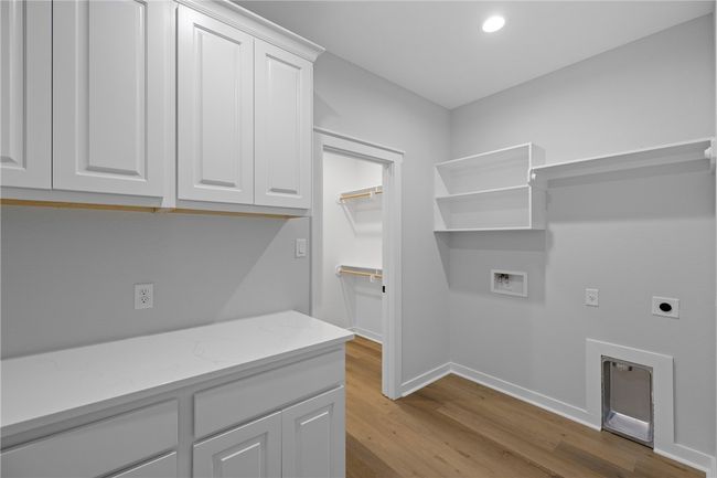 Clothes washing area featuring hookup for an electric dryer, light hardwood / wood-style flooring, washer hookup, and cabinets | Image 21
