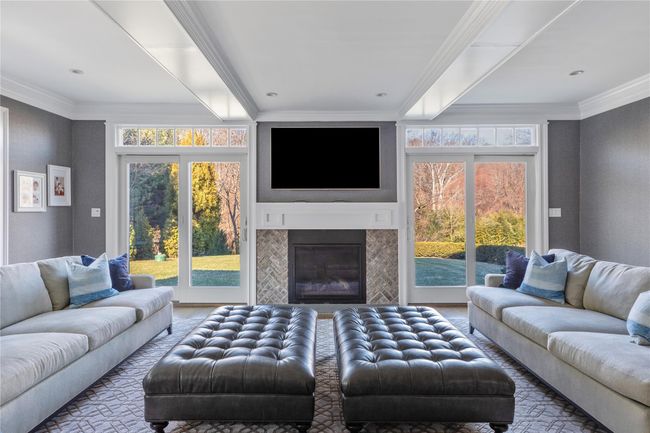 Living room featuring a glass covered fireplace, a wealth of natural light, and crown molding | Image 9