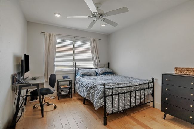Bedroom with wood finished floors and ceiling fan | Image 11