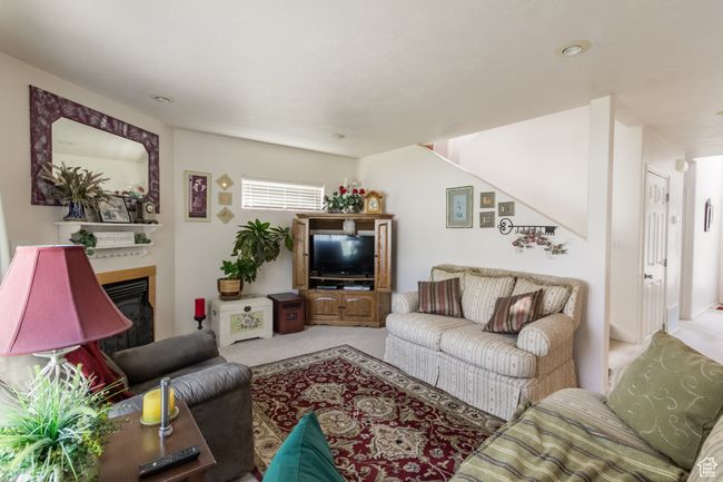 Carpeted living area with a glass covered fireplace | Image 12