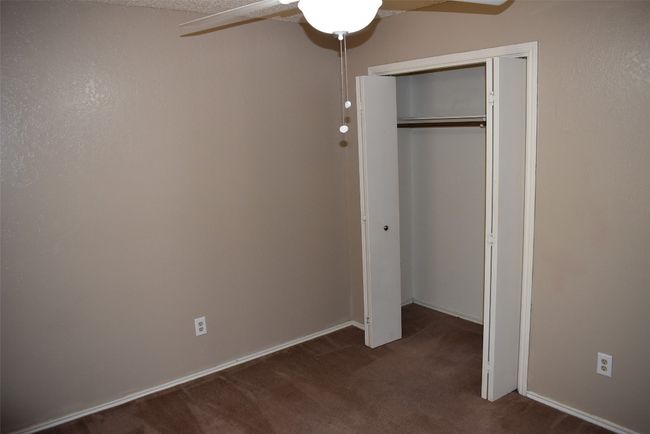 Unfurnished bedroom featuring carpet, a closet, and ceiling fan | Image 10