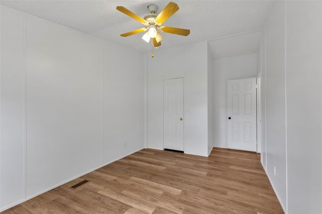 Empty room featuring a ceiling fan and light wood-style flooring | Image 23