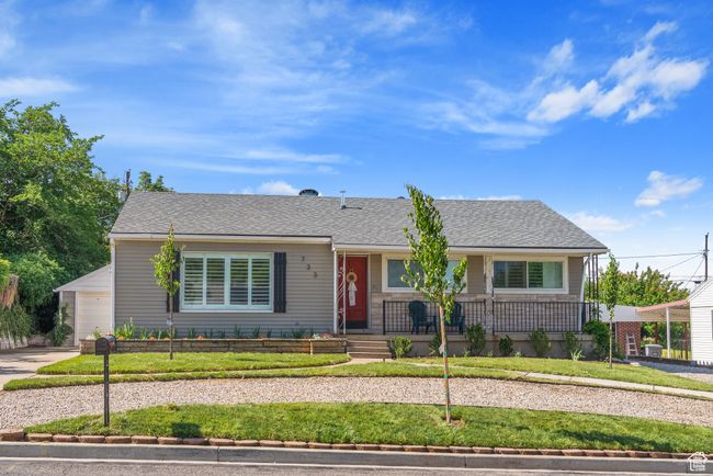 Single story home with a porch, a front lawn, a garage, and driveway | Image 38