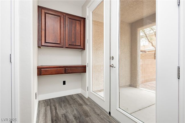 Desk area on bottom level leading to French doors to outside | Image 37