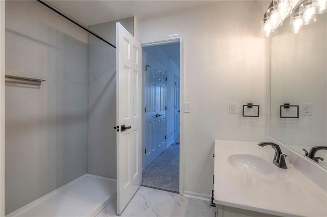 Bathroom featuring marble look tiles and vanity | Image 14