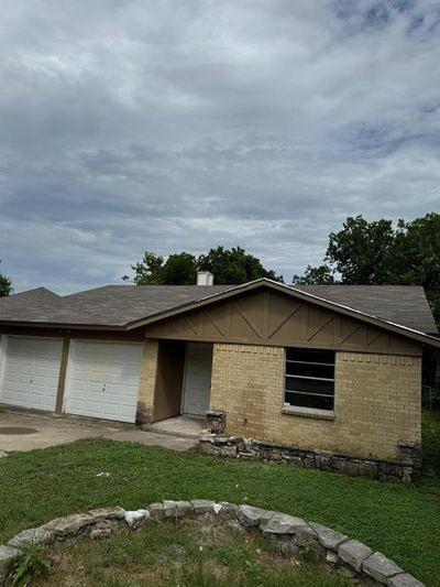 Ranch-style home with a front lawn and a garage | Image 1