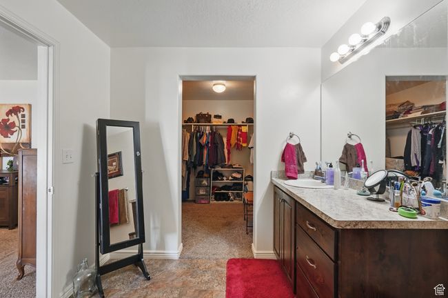 Bathroom with vanity, baseboards, and a spacious closet | Image 23