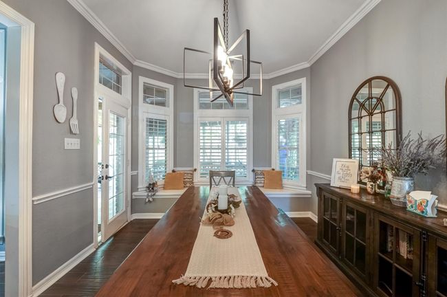 Dining space featuring an inviting chandelier, baseboards, ornamental molding, and dark wood finished floors | Image 14