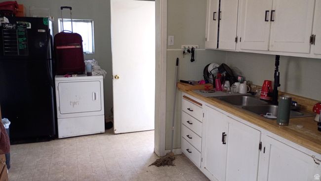 Kitchen with freestanding refrigerator, white cabinets, and light countertops | Image 33