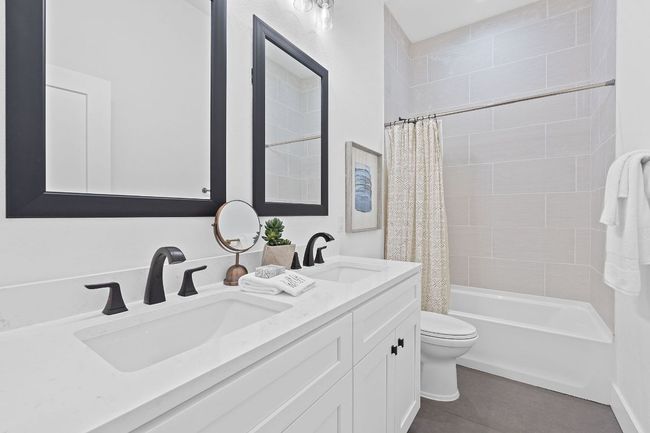 Bathroom featuring tile patterned flooring, dual sink, shower and toilet | Image 21