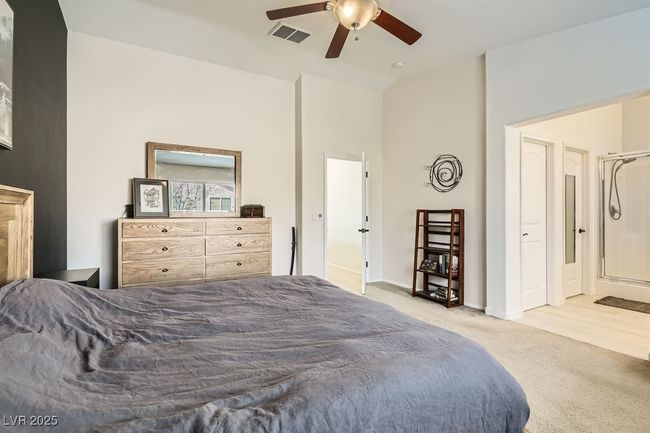 Bedroom with carpet flooring, lofted ceiling, baseboards, visible vents, and ceiling fan | Image 15