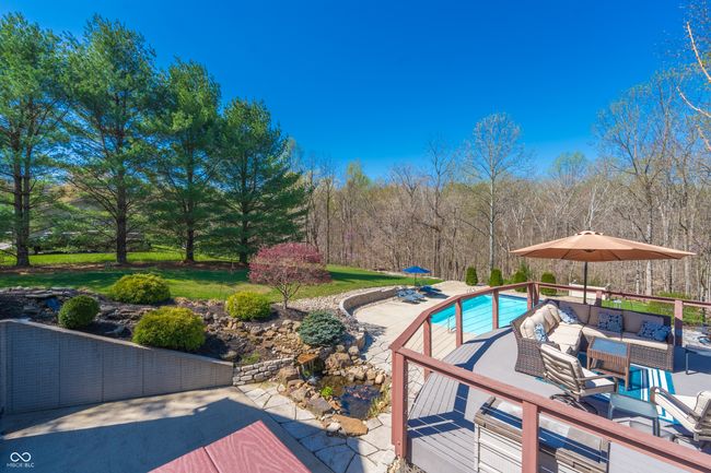 outdoor pool with a view of trees, an outdoor living space, and a patio area | Image 32