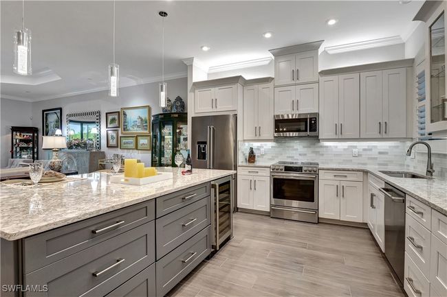 Featuring wine cooler, decorative backsplash, Cambria counters, upgraded stainless steel appliances, lover sized center island gray cabinets | Image 4