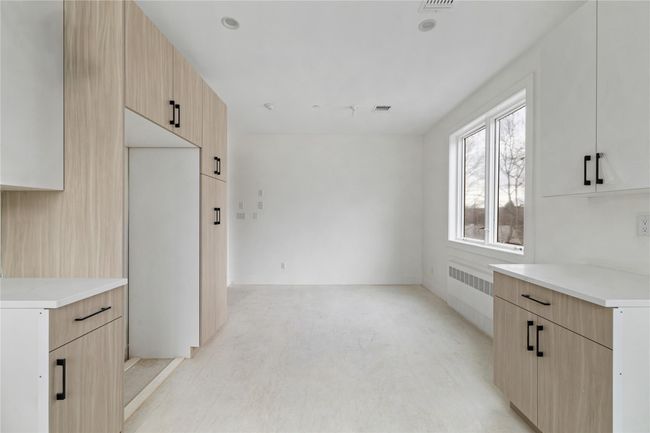 Kitchen with light countertops, light brown cabinets, and modern cabinets | Image 20