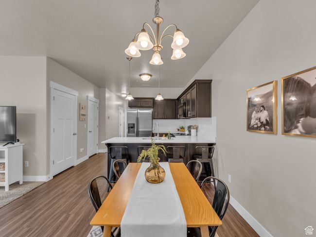 Dining area featuring a chandelier, wood finished floors, and baseboards | Image 4