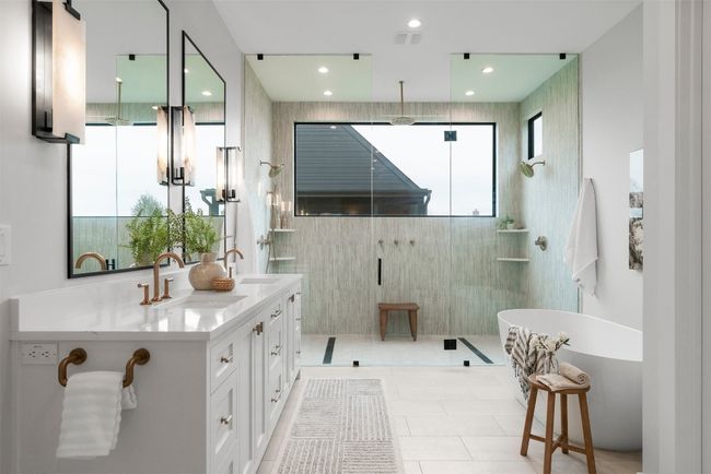 The ensuite bath is a spa-like haven, featuring a deep soaking tub, an oversized walk-in shower with multiple showerheads, and dual vanities that exude elegance and practicality | Image 19