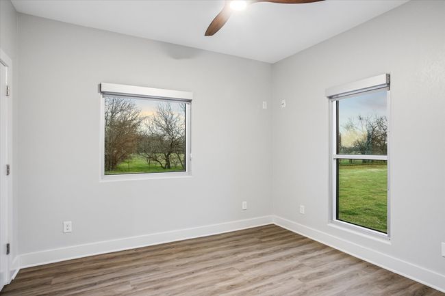 Unfurnished room with hardwood / wood-style flooring, a wealth of natural light, and ceiling fan | Image 17