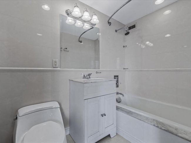 Full bath with tiled shower / bath, vanity, and tile walls | Image 11