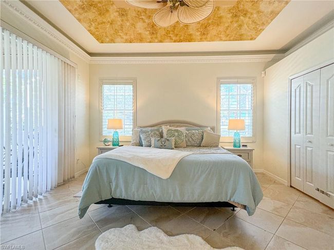 Tiled bedroom with a tray ceiling, a closet, and ceiling fan | Image 43