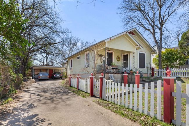 View of front facade featuring a fenced front yard, covered porch, a detached carport, and driveway | Image 32