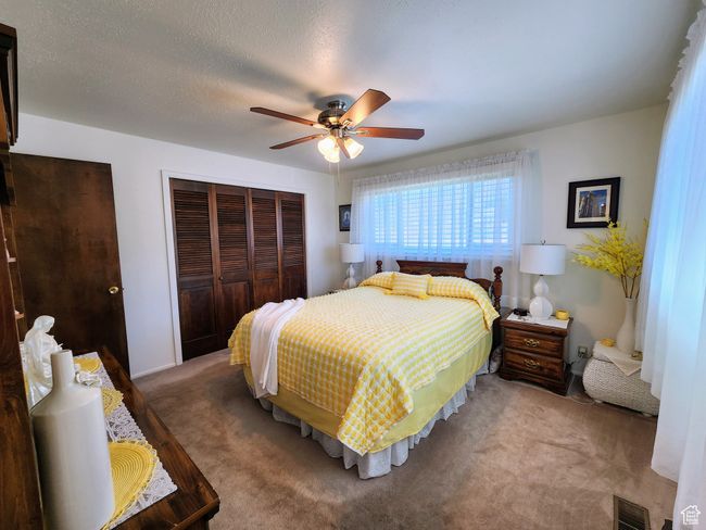 Carpeted bedroom featuring a closet, a ceiling fan, and visible vents | Image 26