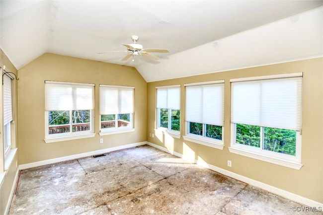 Empty room with vaulted ceiling, visible vents, baseboards, and ceiling fan | Image 14