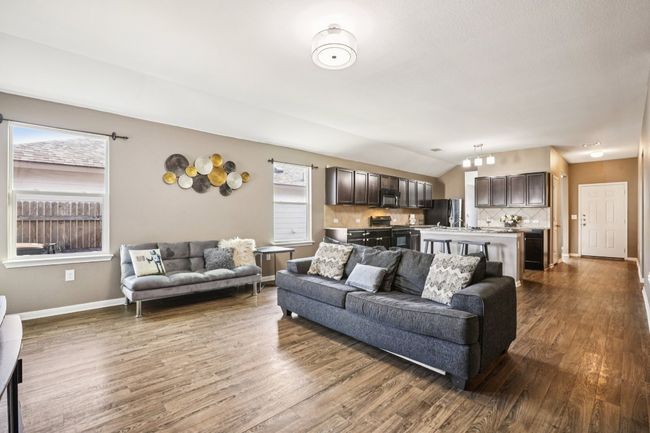 Living room featuring dark wood-style floors and vaulted ceiling | Image 13