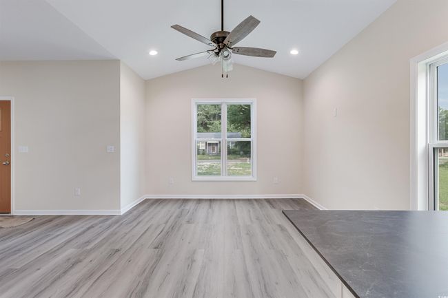 Unfurnished room with light wood-style floors, vaulted ceiling, ceiling fan, and baseboards | Image 12