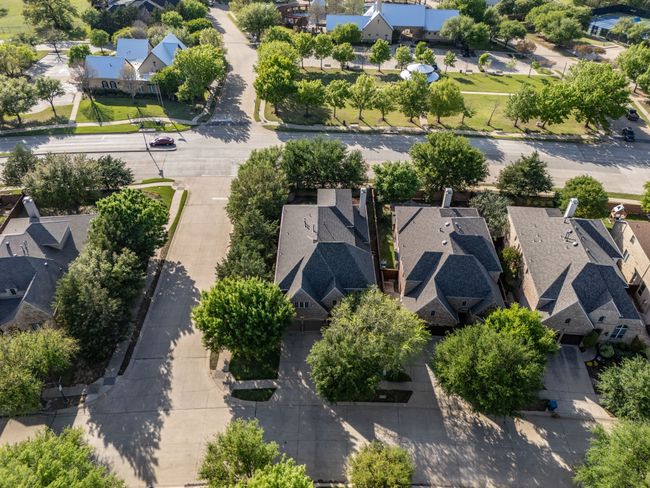 Sitting on a corner lot, the home is surrounded by mature trees and located across the street from the main amenities center and community pool. | Image 32