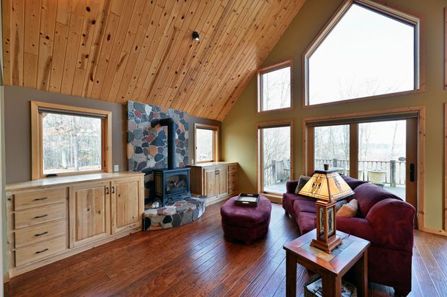 The focal point of the open living spaces is the LP stove fireplace with stone surround. | Image 17
