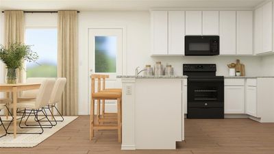 Kitchen featuring black appliances, light stone counters, white cabinets, and light hardwood / wood-style floors | Image 3