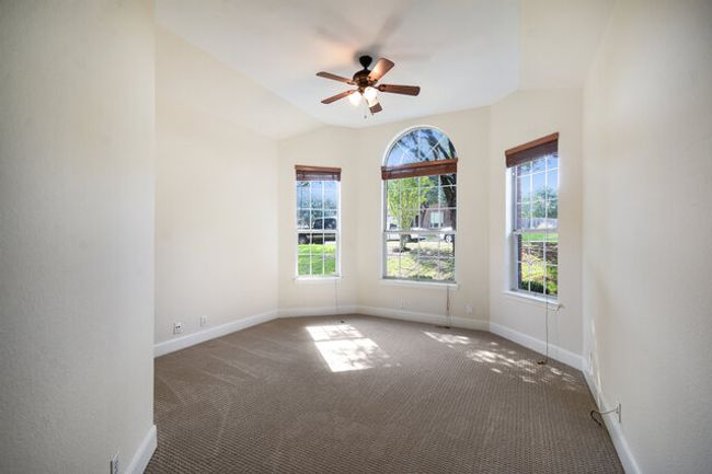 Carpeted empty room with baseboards and a ceiling fan | Image 15