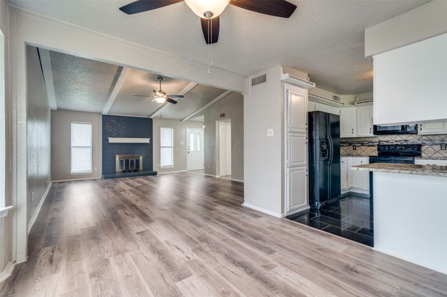 Kitchen featuring black appliances, a ceiling fan, a textured ceiling, backsplash, and white cabinets | Image 5