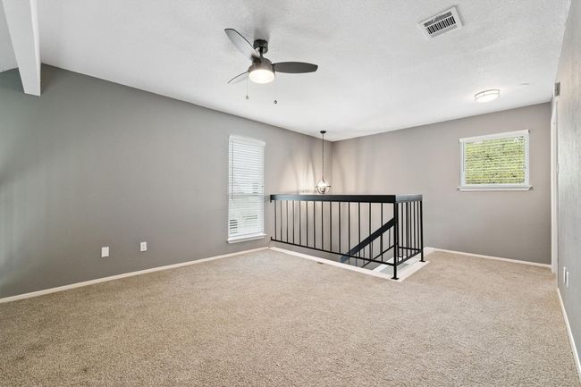 Carpeted spare room featuring a ceiling fan, baseboards, beamed ceiling, and a textured ceiling | Image 20