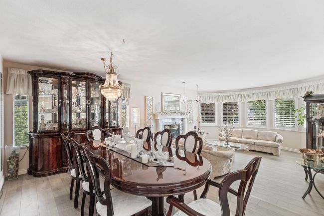 Dining room featuring a chandelier, healthy amount of natural light, light wood-style flooring, and baseboards | Image 5