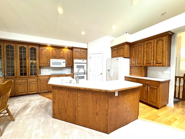 Vaulted kitchen with dual ovens and built in glass cabinets and hardwood floor. | Image 10