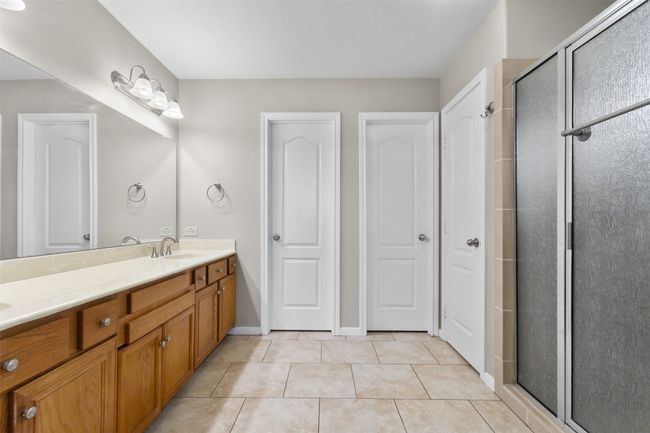 Bathroom with double vanity, an enclosed shower, and tile patterned floors | Image 17