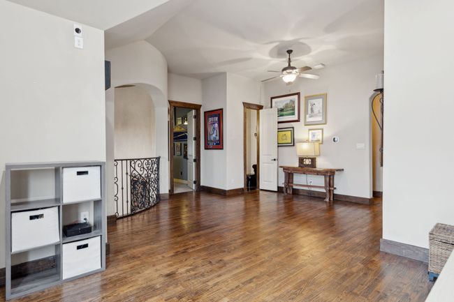 Living room with arched walkways, wood finished floors, a ceiling fan, and baseboards | Image 26