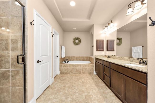 The large Primary ensuite bathroom includes a huge walk-in closet, soaking tub, separate shower, double sinks, and a linen closet. | Image 16