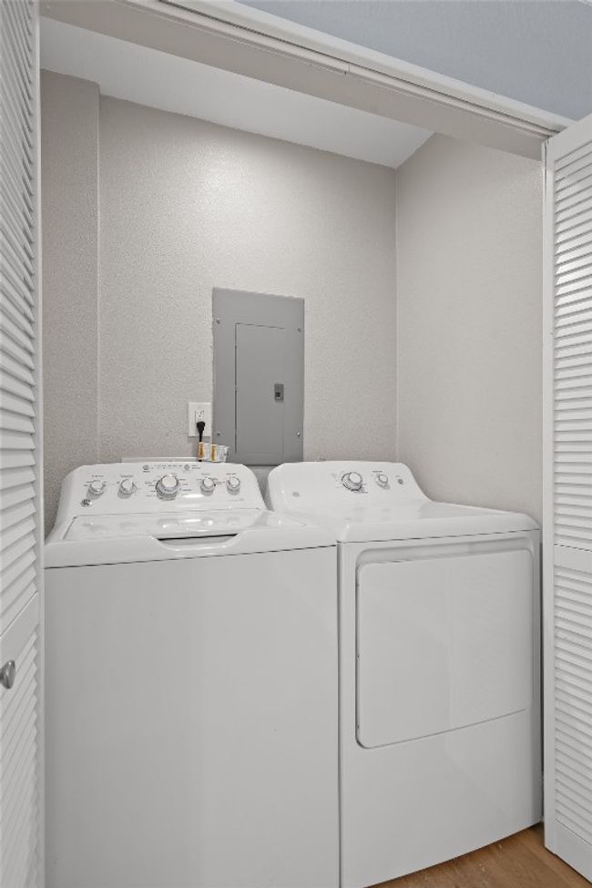 Laundry area with laundry area, electric panel, washing machine and dryer, and wood finished floors | Image 29