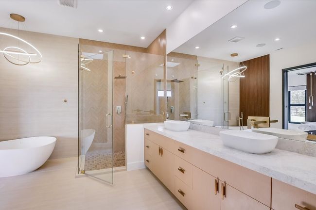 Full Primary bathroom with double vanity, a large glassed in shower, a freestanding soaking tub, recessed lighting, and a chandelier | Image 26