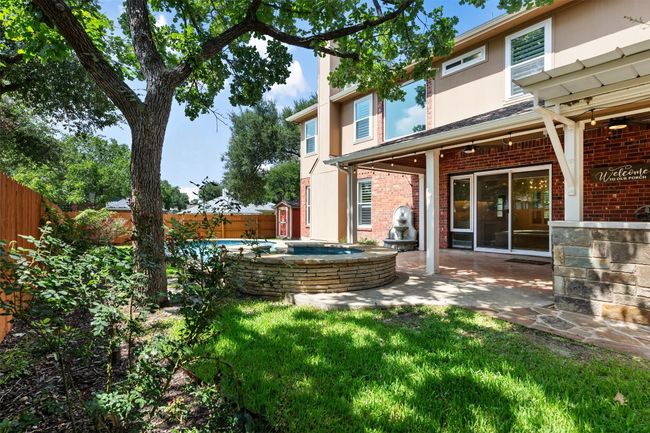 Fenced backyard featuring a pool with connected hot tub and a patio area | Image 40