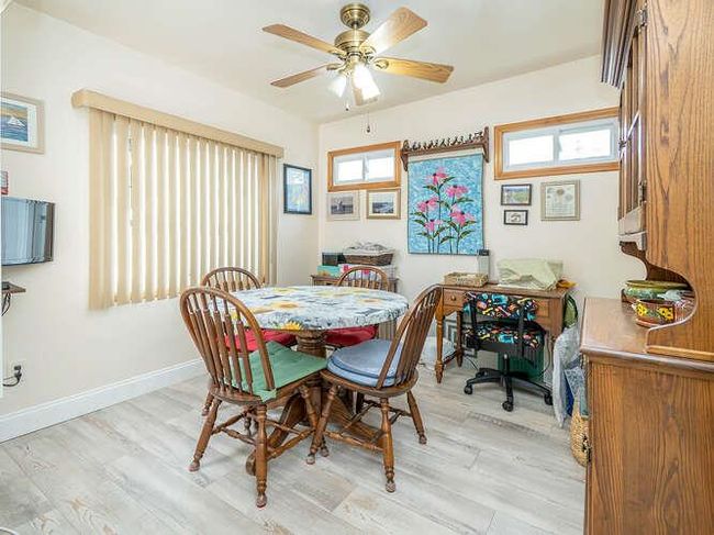 Dining area featuring light wood finished floors, baseboards, and ceiling fan | Image 7