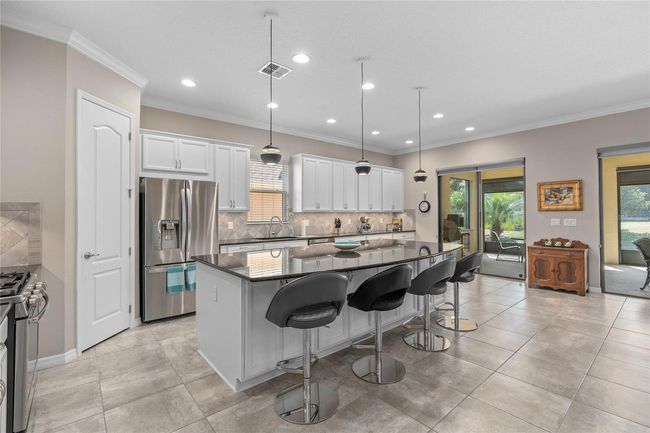 A Beautiful Kitchen offers a Corner Pantry, Large Island with Breakfast Bar and an Extended Dinette Area. Plenty of Cabinetry for your Storage needs. Please note the additional Cabinetry under the Breakfast Bar. | Image 17